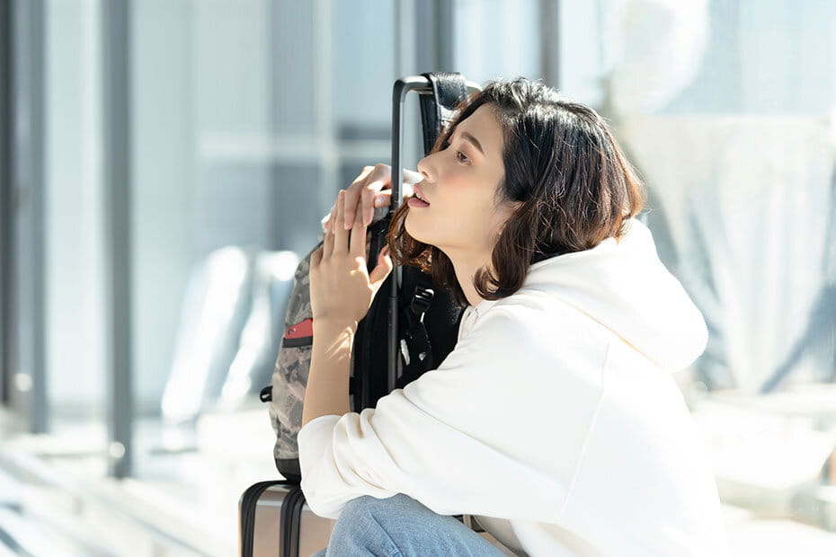 時間つぶしをする女性ツーリスト