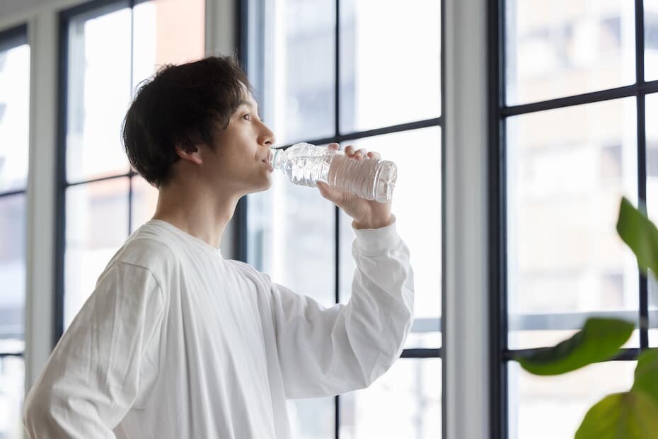 ペットボトルの水を飲む男性