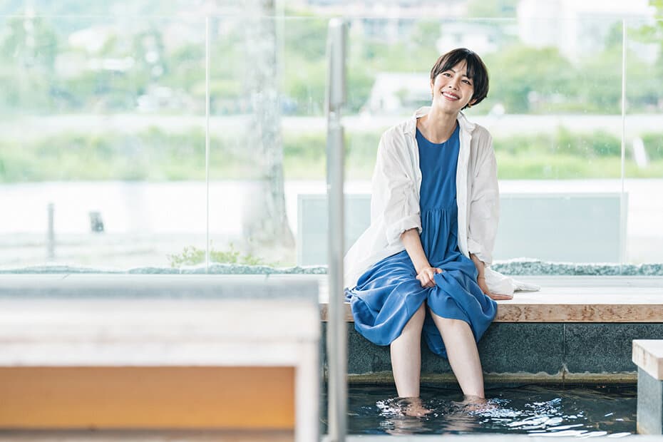 足湯に浸かって癒される女性