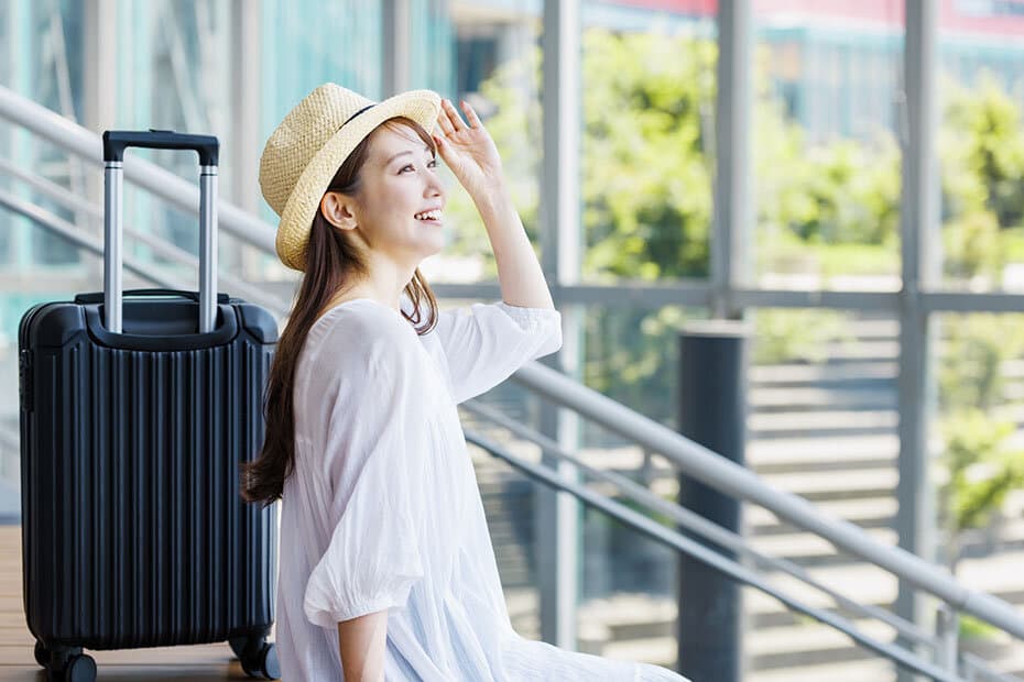 麦わら帽子をかぶって観光を楽しむ若い女性