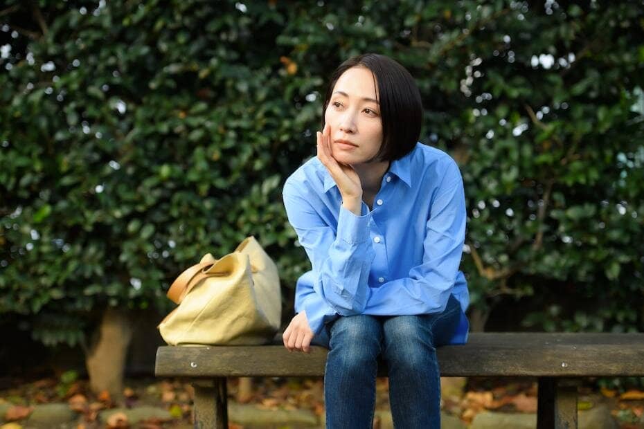 ベンチで空想にふける女性