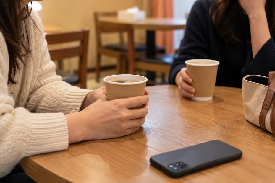 コーヒーを手に出発を待つ旅行者の手元