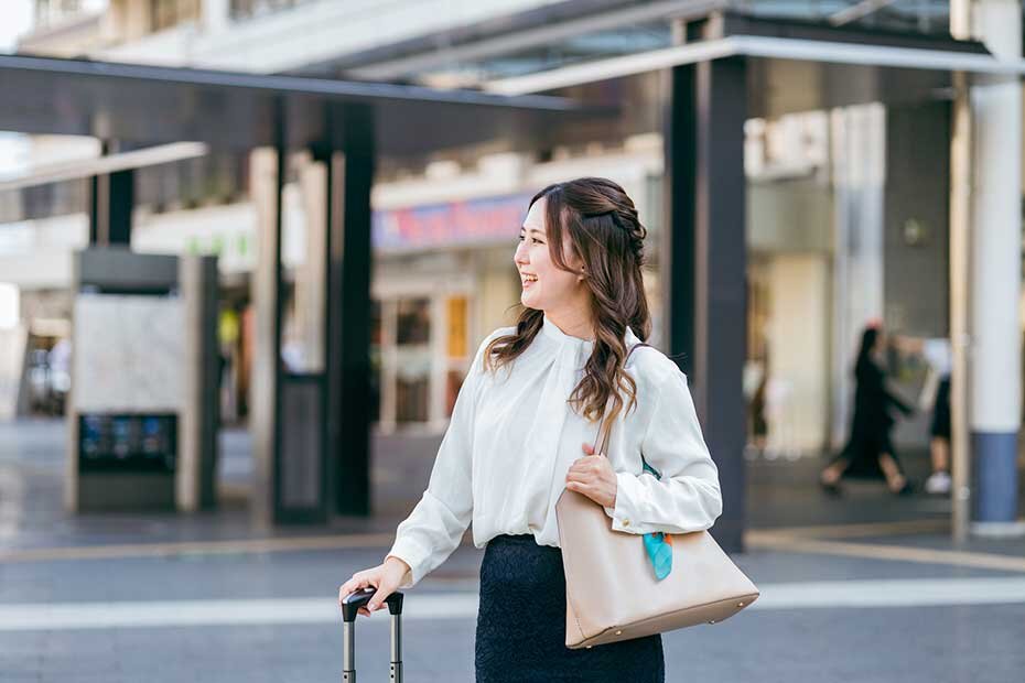 荷物を持って移動中の女性