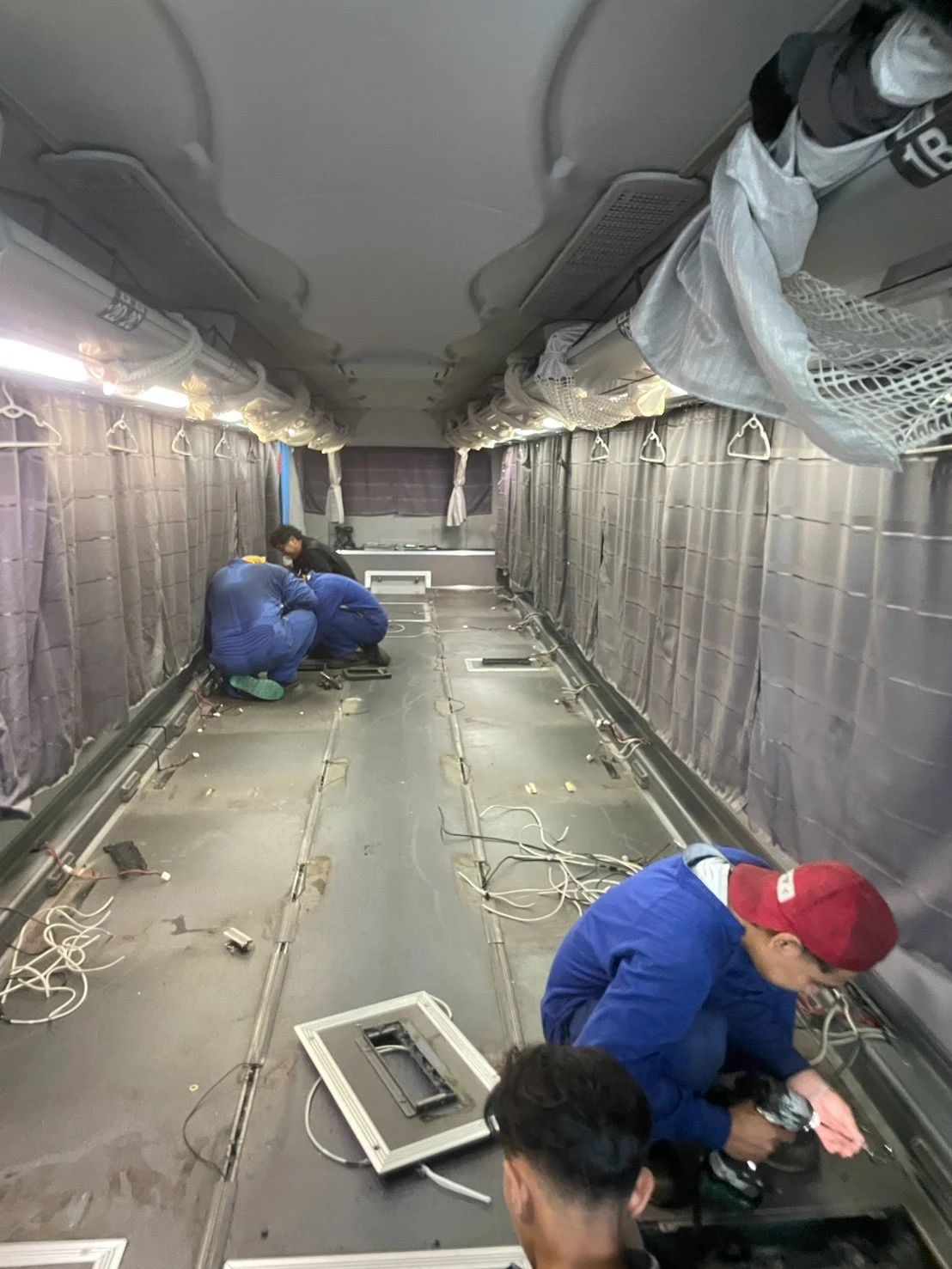 座席を取り外して交換作業を進めるバスの車内